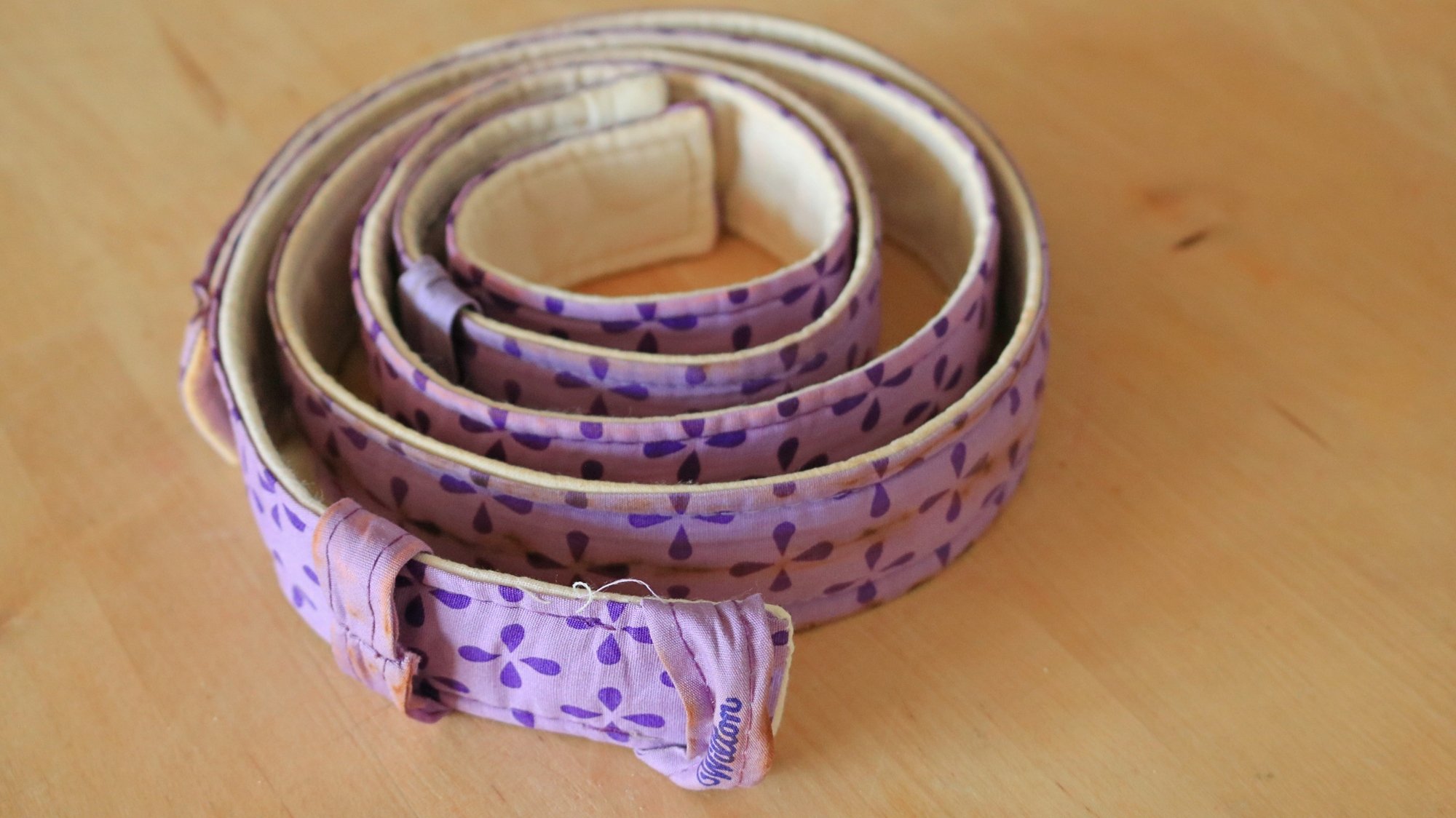 Cake strips wrapped in a circle on a wooden counter top.